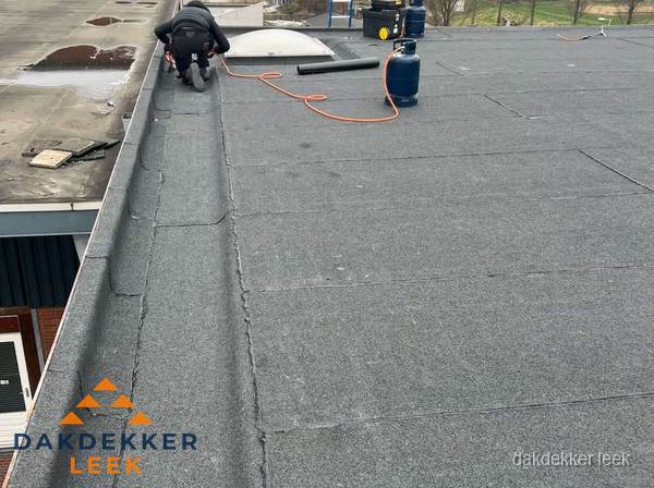 Dakdekker repareert bitumen dakbedekking op groot plat dak in Leek Dakdekker repareert bitumen dakbedekking op groot plat dak in Leek