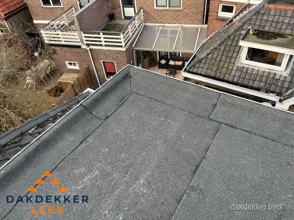 Overzicht plat dak met dakgoot in woonwijk Leek Overzicht plat dak met dakgoot in woonwijk Leek